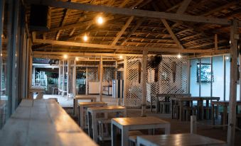 a large , open dining room with wooden tables and chairs arranged for a group of people to enjoy a meal together at Cabana Retreat - Glamping