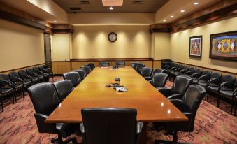 a large conference room with a wooden table and black chairs , surrounded by bookshelves and other office furniture at Four Winds Casino Resort – New Buffalo