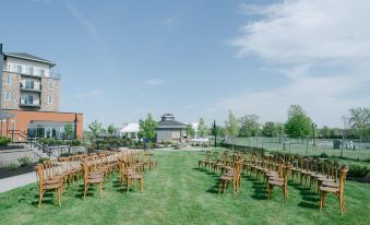 a large outdoor wedding venue with rows of wooden chairs set up for an event at Hotel Canandaigua, Tapestry Collection by Hilton