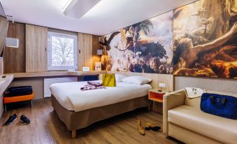 a modern hotel room with wooden flooring , white bed , and large mural on the wall at Ibis Styles Lille Marcq-en-Baroeul