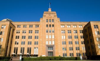 "a large building with a flag on top and the words "" hsbc "" written in front" at Coogee Sands Hotel & Apartments