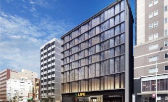 A spacious building with a front facade and windows on both sides, displaying an office area at Richmond Hotel Tokyo Suidobashi