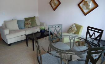 a living room with a couch , dining table , chairs , and a tv . also a chair in the room at Country Cove