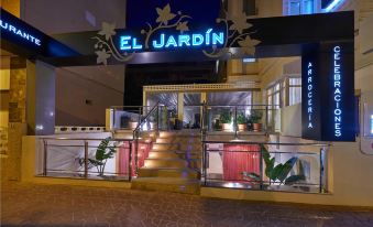 "a restaurant with a neon sign that reads "" el jardin "" on the side of the building" at Hotel Meridional