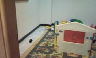 a room with a play area for children , including a car and toys , on the floor at Hotel Majestic