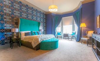 a luxurious bedroom with blue and purple walls , a large bed , and various pieces of furniture at Richmond Park Hotel