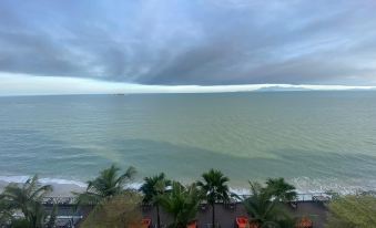 a view of the ocean from a high vantage point , with palm trees and umbrellas visible in the foreground at Hompton Hotel by The Beach