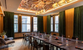 a large conference room with multiple rows of chairs arranged in a semicircle , and a long table in the center at Canopy by Hilton Philadelphia Center City