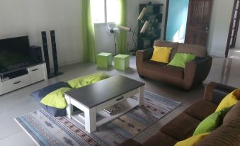 a living room with a brown couch , coffee table , and bean bag chairs on the floor at The Sanctuary