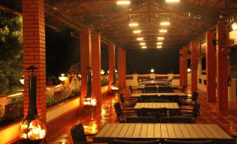 an outdoor dining area with several tables and chairs , surrounded by brick walls and lit by candles at Park Royale