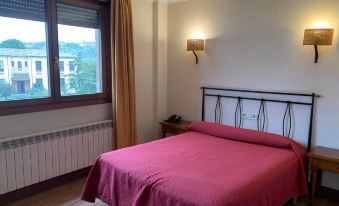 a bedroom with a bed and red blanket , next to a window with a view at Rivera del Duero