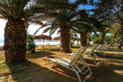 a sandy beach with several lounge chairs and umbrellas , creating a relaxing atmosphere for beachgoers at Hotel Summery