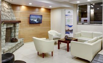 a modern waiting room with white chairs and a tv on the wall , creating a comfortable and inviting atmosphere at Cambria