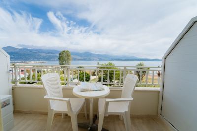 a white table and two chairs on a balcony overlooking a beautiful view of the ocean at Hotel Summery