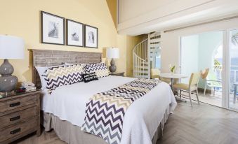 a spacious bedroom with a large bed , a dining area , and a staircase leading to a loft at Oyster Bay Beach Resort