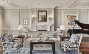 a living room with a couch , chairs , and a piano in front of a fireplace at Rosewood Miramar Beach