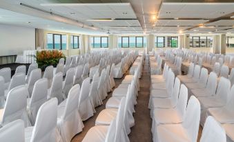 a large conference room with rows of chairs and tables , all covered in white tablecloths at Grand Mercure Recife Boa Viagem