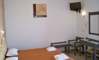 a small hotel room with a single bed , a tv , and a desk , all arranged neatly at Palladion