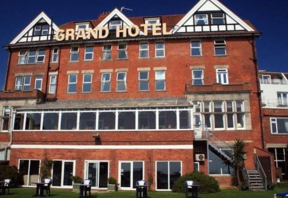 "a large brick hotel building with the words "" grand hotel "" prominently displayed on the front" at Grand Hotel Swanage