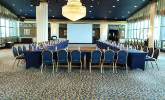 a large conference room with multiple tables and chairs arranged for a meeting or event at Le Royal Hotel - Beirut