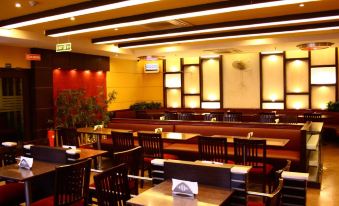 The restaurant features wooden tables and chairs in the center, as well as additional seating areas at Ginger Hotel  Delhi Rail Yatri Niwas  Irctc