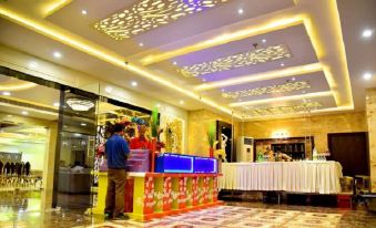 a well - lit hotel lobby with a buffet table and a man standing near it , ready to serve customers at The Riverside Inn