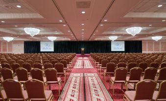 a large conference room with rows of chairs and a long red carpet at the front at Hilton St. Louis Frontenac