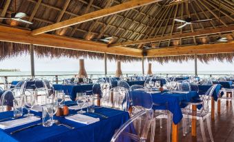 an outdoor dining area with a blue tablecloth , chairs , and tables set up for a party or event at Hotel Las Islas