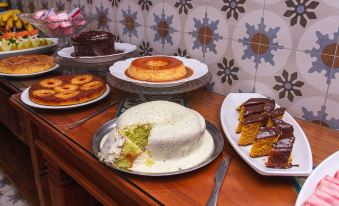 a dining table with a variety of desserts , including cakes and pies , placed on plates at Pousada Tesouro de MInas