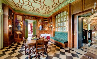 a dining room with a wooden table , chairs , and a checkered floor , as well as a living room with a couch and a dining at Chateau de la Bourdaisiere