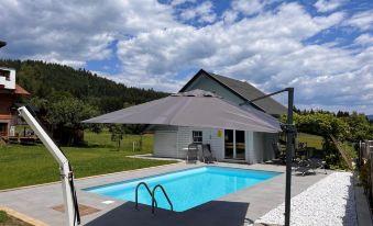 a small backyard with a swimming pool surrounded by green grass and a gazebo , as well as a house in the background at Frank