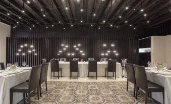 a conference room with black walls , a chandelier , and a table set for a meeting at Alba Palace Hotel