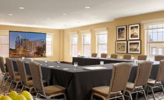 a conference room set up for a meeting , with tables and chairs arranged in a semicircle at The Moonrise Hotel