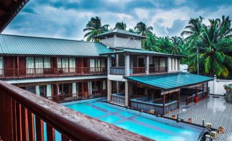 a tropical resort with a swimming pool , surrounded by palm trees and lush greenery , under a cloudy sky at Holiday Inn Beach Resort