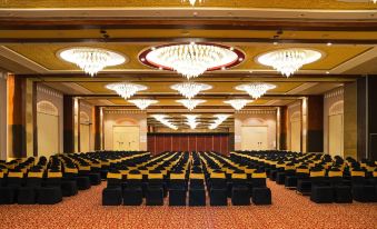 a large , empty conference room with rows of chairs and chandeliers hanging from the ceiling at Resort Rio