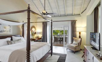 a spacious bedroom with a four - poster bed and a sliding glass door leading to a balcony at Colony Club by Elegant Hotels