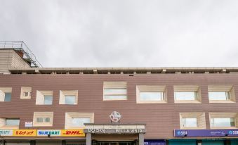 "a brown building with a sign that says "" esprit "" and other shops on the side" at Hotel Bella Vista