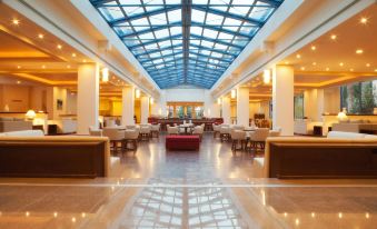 a large , modern hotel lobby with high ceilings , marble floors , and multiple couches and chairs at Alkyon Resort Hotel & Spa