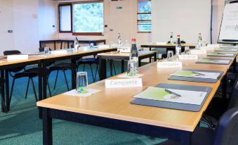 a conference room with multiple tables , each equipped with a name tag and name plates at Campanile Paris Est - Bobigny