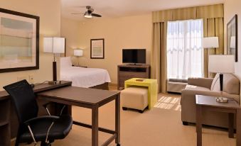 a hotel room with a bed , desk , and chair , along with various pieces of furniture at Homewood Suites by Hilton Houma