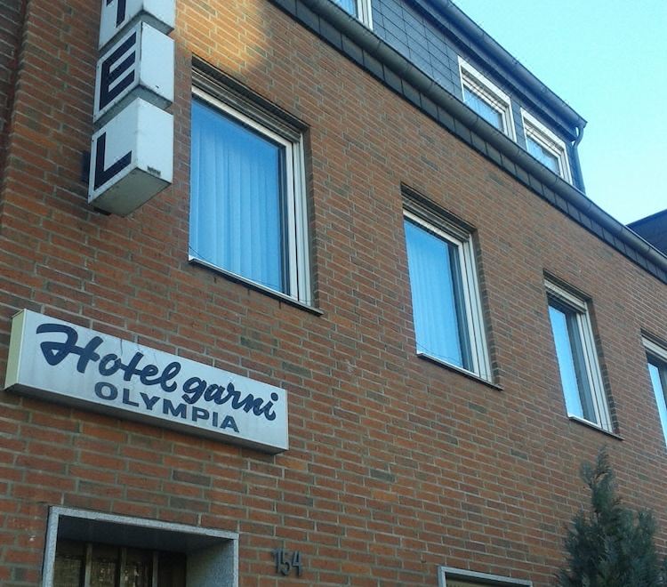 a brick building with a hotel sign on the side , likely a hotel or motel at Hotel Olympia