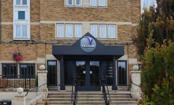 the exterior of the village hotel , a large building with a blue sign and two black staircases at Village Hotel Birmingham Dudley