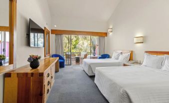 a hotel room with two beds , a tv , and a balcony overlooking a beautiful view at Hotel Rancho San Diego Grand Spa Resort