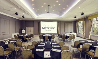 a large conference room with multiple tables and chairs arranged for a meeting or event at Mercure Bradford Bankfield Hotel