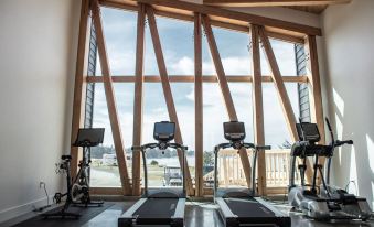 a gym with two treadmills and exercise bikes in front of a large window , offering a view of the outdoors at Bay Point Landing