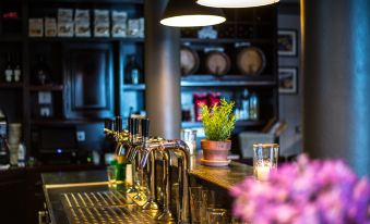a bar with multiple bottles of wine and a potted plant on the counter , creating a cozy atmosphere at Bischoffs