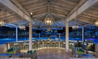 a large indoor pool area with a bar and lounge chairs under a wooden ceiling at Harrah's Ak-Chin Casino Resort