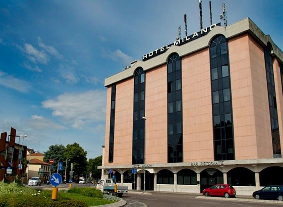 "a large , modern building with the sign "" hotel chandigarh "" on top , surrounded by trees and cars in front of it" at Hotel Milano