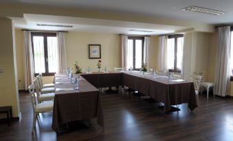 a large conference room with multiple tables and chairs arranged in a semicircle , providing seating for a group of people at Villa Turistica de Bubion