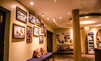 a hallway with a row of framed pictures on the wall and a blue bench at Nile Village Hotel & Spa